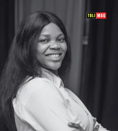 Portrait d'Astride Masengu Kikongo, jeune femme congolaise souriante en tenue professionnelle, devant un ordinateur, incarnant la tech et le leadership féminin en RDC